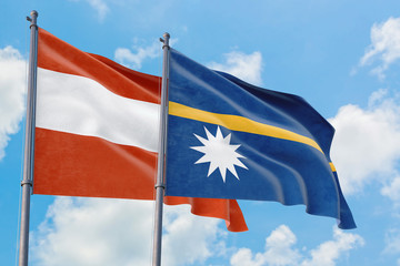 Nauru and Austria flags waving in the wind against white cloudy blue sky together. Diplomacy concept, international relations.