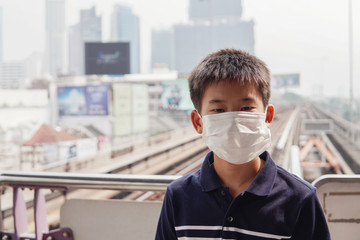 Young Asian preteen boy wearing medical face mask,  Wuhan coronavirus outbreak, pm 2.5 air pollution and health concept
