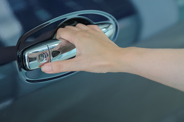 Woman hand on open the new car door