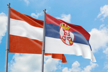 Serbia and Austria flags waving in the wind against white cloudy blue sky together. Diplomacy concept, international relations.