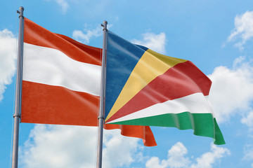 Seychelles and Austria flags waving in the wind against white cloudy blue sky together. Diplomacy concept, international relations.