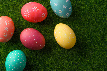Easter eggs colored on green grass. Congratulations on Easter. Horizontal frame.