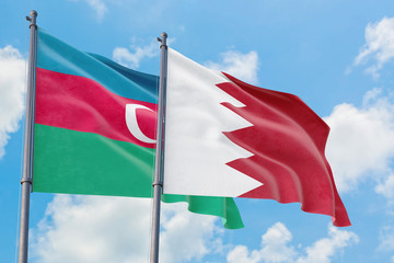 Bahrain and Azerbaijan flags waving in the wind against white cloudy blue sky together. Diplomacy concept, international relations.
