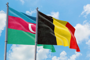Belgium and Azerbaijan flags waving in the wind against white cloudy blue sky together. Diplomacy concept, international relations.