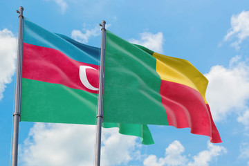 Benin and Azerbaijan flags waving in the wind against white cloudy blue sky together. Diplomacy concept, international relations.