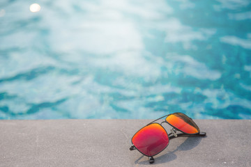 Fototapeta na wymiar Fashion sun glasses near the swimming pool