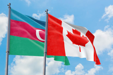 Canada and Azerbaijan flags waving in the wind against white cloudy blue sky together. Diplomacy...