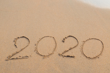 Abstract message Year 2020 written on beach sand