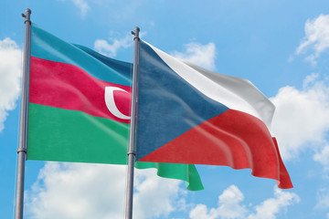 Czech Republic and Azerbaijan flags waving in the wind against white cloudy blue sky together. Diplomacy concept, international relations.