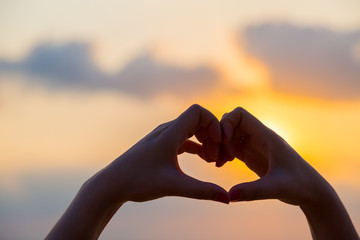 Hands make in heart form love with silhouette at sun set