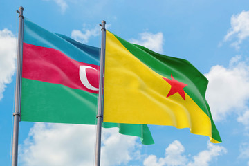 French Guiana and Azerbaijan flags waving in the wind against white cloudy blue sky together. Diplomacy concept, international relations.