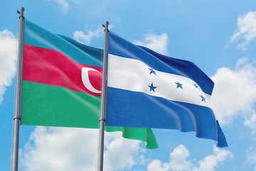 Honduras and Azerbaijan flags waving in the wind against white cloudy blue sky together. Diplomacy concept, international relations.