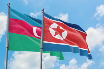 North Korea and Azerbaijan flags waving in the wind against white cloudy blue sky together. Diplomacy concept, international relations.