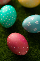 Easter eggs colored on green grass. Congratulations on Easter. Vertical frame.
