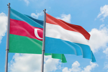 Fototapeta na wymiar Luxembourg and Azerbaijan flags waving in the wind against white cloudy blue sky together. Diplomacy concept, international relations.