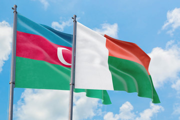 Madagascar and Azerbaijan flags waving in the wind against white cloudy blue sky together. Diplomacy concept, international relations.