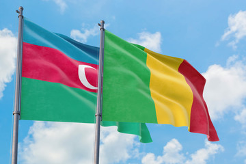 Mali and Azerbaijan flags waving in the wind against white cloudy blue sky together. Diplomacy concept, international relations.