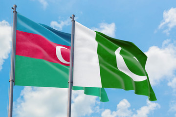 Pakistan and Azerbaijan flags waving in the wind against white cloudy blue sky together. Diplomacy concept, international relations.
