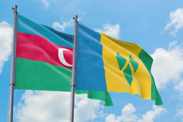 Saint Vincent And The Grenadines and Azerbaijan flags waving in the wind against white cloudy blue sky together. Diplomacy concept, international relations.
