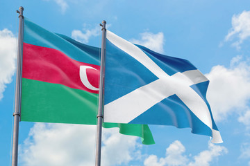 Scotland and Azerbaijan flags waving in the wind against white cloudy blue sky together. Diplomacy concept, international relations.