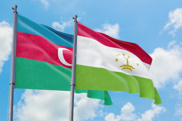 Tajikistan and Azerbaijan flags waving in the wind against white cloudy blue sky together. Diplomacy concept, international relations.