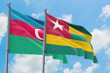 Togo and Azerbaijan flags waving in the wind against white cloudy blue sky together. Diplomacy concept, international relations.