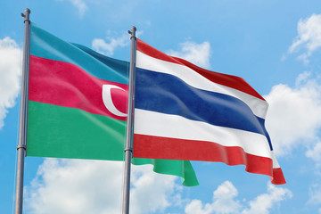 Thailand and Azerbaijan flags waving in the wind against white cloudy blue sky together. Diplomacy concept, international relations.
