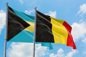 Belgium and Bahamas flags waving in the wind against white cloudy blue sky together. Diplomacy concept, international relations.