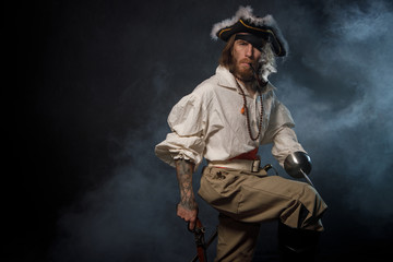Fototapeta na wymiar Portrait of pirate filibuster sea robber in suit with guns. Concept photo