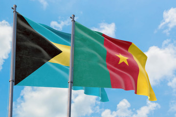 Cameroon and Bahamas flags waving in the wind against white cloudy blue sky together. Diplomacy concept, international relations.