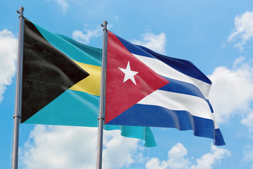 Cuba and Bahamas flags waving in the wind against white cloudy blue sky together. Diplomacy concept, international relations.