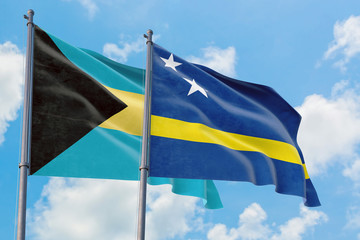 Curacao and Bahamas flags waving in the wind against white cloudy blue sky together. Diplomacy concept, international relations.
