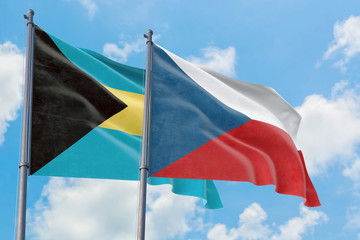 Czech Republic and Bahamas flags waving in the wind against white cloudy blue sky together. Diplomacy concept, international relations.