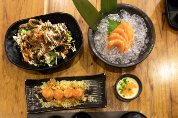 Salmon meal on table; salmon steak, sashimi, maki, steam egg and salad with crispy skin salmon. Healthy food with rich in omega-3 meal.