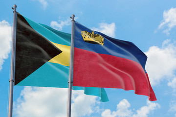 Liechtenstein and Bahamas flags waving in the wind against white cloudy blue sky together. Diplomacy concept, international relations.