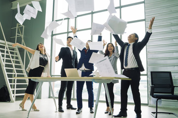 business people excited happy smile,Group of confident business people throwing paper in air while working behind the glass wall,Success team concept.