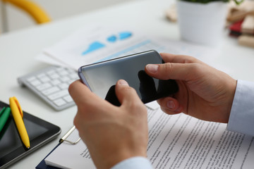 A businessman holds a new smartphone in his hand The mobile application market shows a display you can insert your image for advertising or financial statistics.