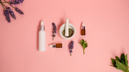 skin care product on pink flat lay backgroung . organic beauty essential oil with herbal and lavender.aromatheraphy for wellness and sp concept.
