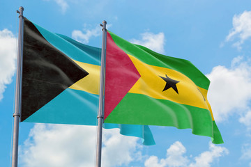 Sao Tome And Principe and Bahamas flags waving in the wind against white cloudy blue sky together. Diplomacy concept, international relations.
