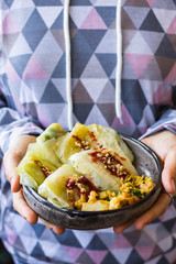 Cabbage rolls with mushrooms and tomato paste sauce walnuts topping. Healthy dietary vegan food. Woman holds cabbage rolls
