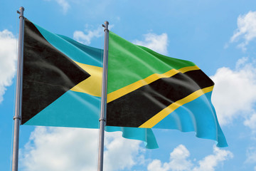 Tanzania and Bahamas flags waving in the wind against white cloudy blue sky together. Diplomacy concept, international relations.