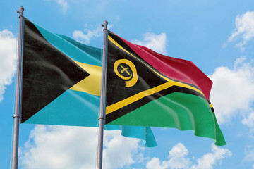 Vanuatu and Bahamas flags waving in the wind against white cloudy blue sky together. Diplomacy concept, international relations.