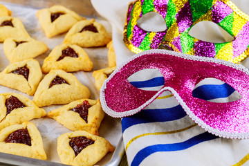 Hamantaschen cookies on baking tray with tallit and mask.
