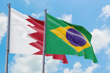 Brazil and Bahrain flags waving in the wind against white cloudy blue sky together. Diplomacy concept, international relations.