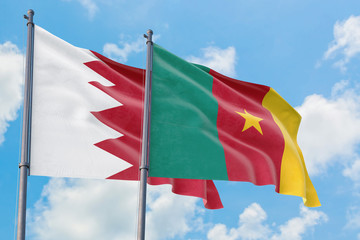 Cameroon and Bahrain flags waving in the wind against white cloudy blue sky together. Diplomacy concept, international relations.