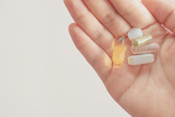 Top view of alternative organic medicine or herbal viatmin supplement capsule tablet on woman hand with copyspace background.