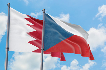 Czech Republic and Bahrain flags waving in the wind against white cloudy blue sky together. Diplomacy concept, international relations.
