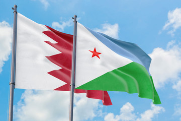 Djibouti and Bahrain flags waving in the wind against white cloudy blue sky together. Diplomacy concept, international relations.