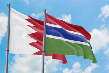 Fototapeta na wymiar Gambia and Bahrain flags waving in the wind against white cloudy blue sky together. Diplomacy concept, international relations.