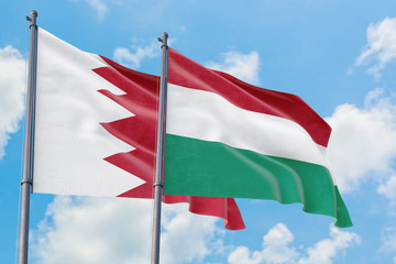Fototapeta na wymiar Hungary and Bahrain flags waving in the wind against white cloudy blue sky together. Diplomacy concept, international relations.